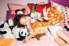 Little girl surrounded by stuffed animals