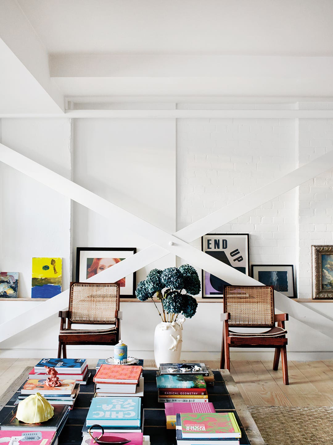 White living room with X-beam crossing in front of art