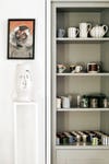 Mug open shelving painted in a neutral gray
