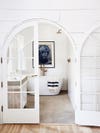 White archway with doors leading to bathtub