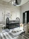 Nursery with black crib, disco ball, and art that reads, "The Coast Is Clear."