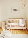 Neutral-toned nursery with wave art print.