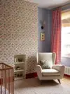 Nursery with floral wallpaper and red gingham curtains.