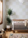 Nursery with white and beige checkerboard wallpaper.