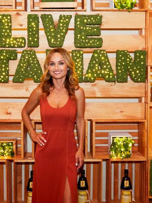 Giada De Laurentiis standing in front of a sign that says #live italian
