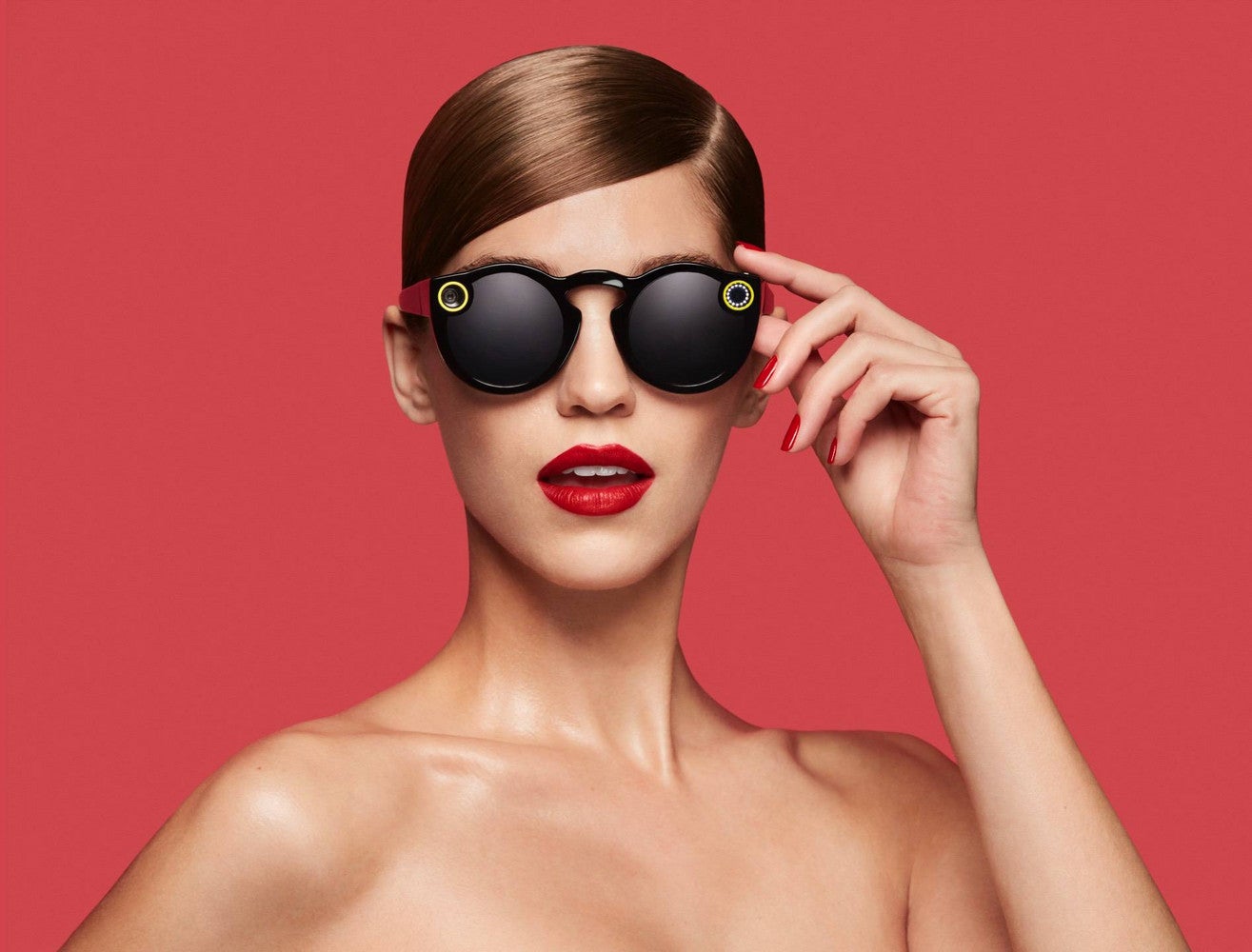 snapchat spectacles woman with black snapchat spectacles on red background