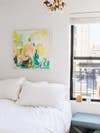 whitewashed bedroom with colorful artwork