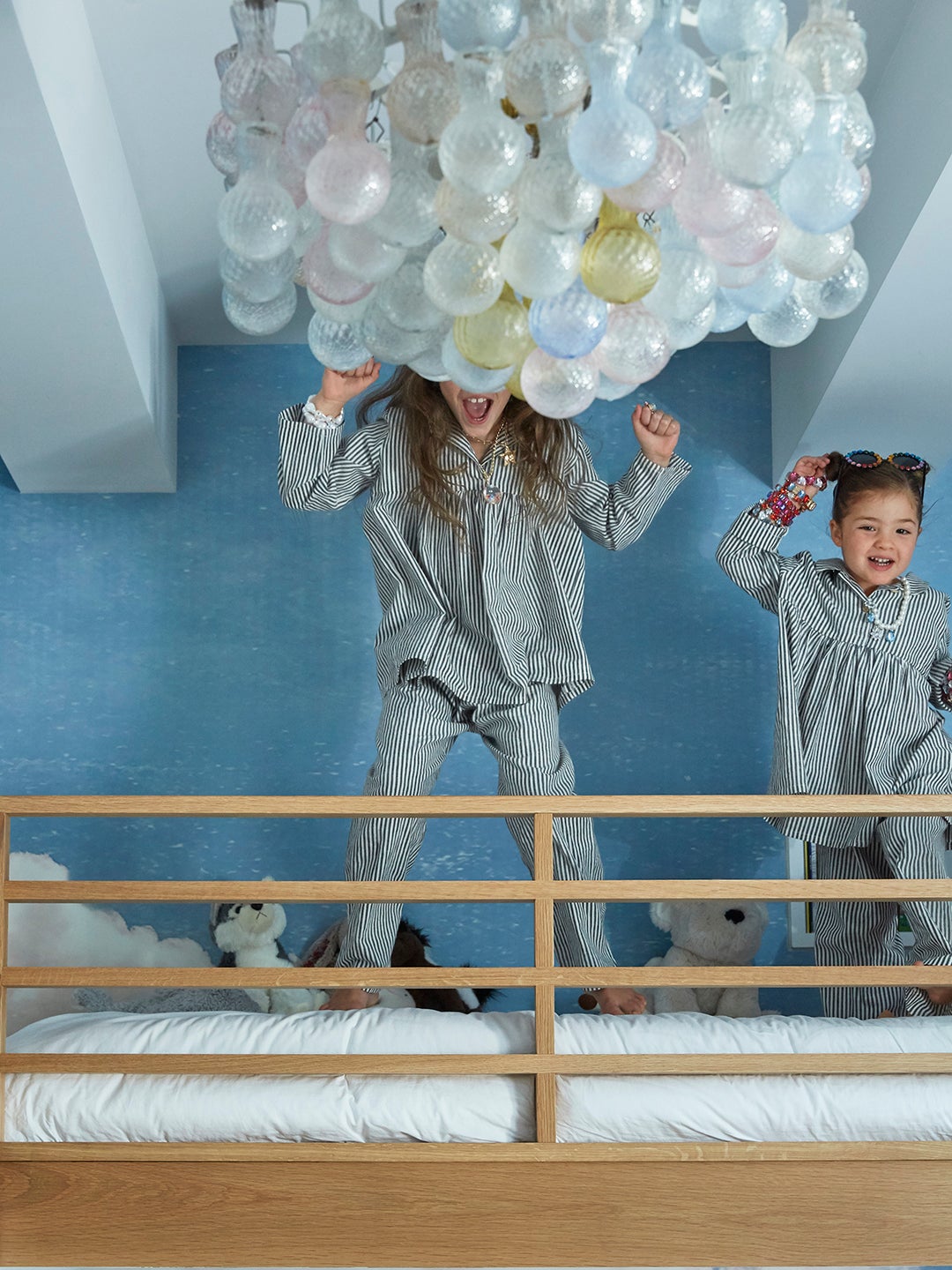 two daughters in PJs jumping on bunk bed