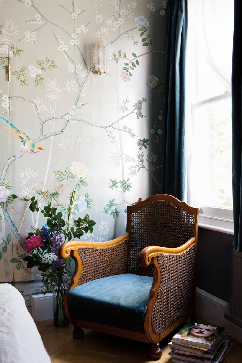 A vintage cane chair in the bedroom was picked up at Brick Lane Market when the couple first started dating. “James carried it for blocks and blocks over his head to the car. It’s so heavy,” says Clark. The hand-painted de Gournay wallpaper is “maybe my favorite thing in our house—definitely the most luxurious!”