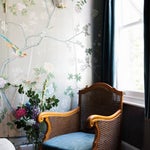 A vintage cane chair in the bedroom was picked up at Brick Lane Market when the couple first started dating. “James carried it for blocks and blocks over his head to the car. It’s so heavy,” says Clark. The hand-painted de Gournay wallpaper is “maybe my favorite thing in our house—definitely the most luxurious!”