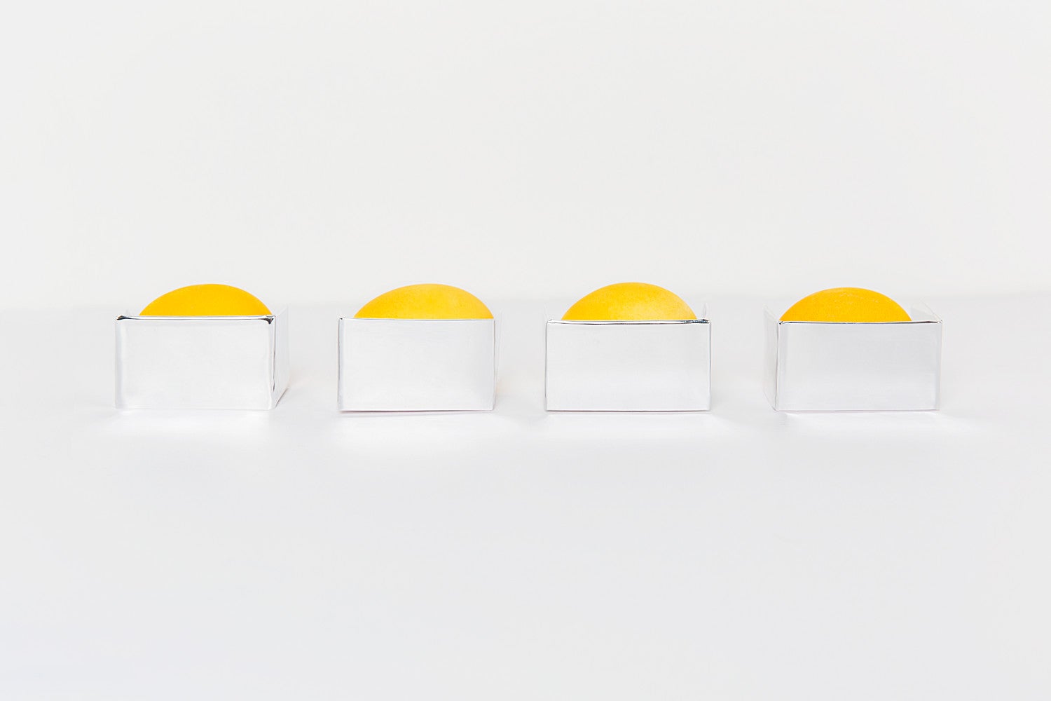 bright yellow Easter eggs in silver boxes