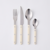 four pieces of sabre flatware with cream acrylic handles