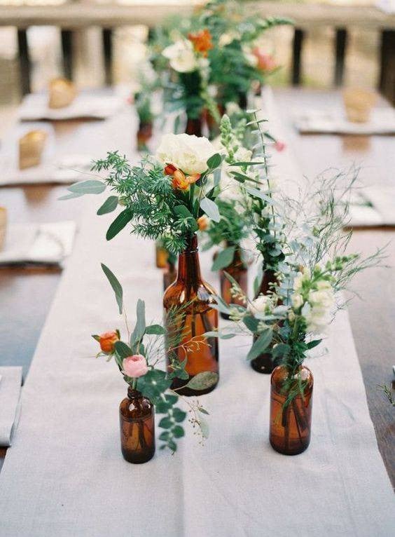 Easy Spring Centerpieces brown bottles with green and white flowers