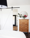 domino magazine white bedroom with wooden dresser