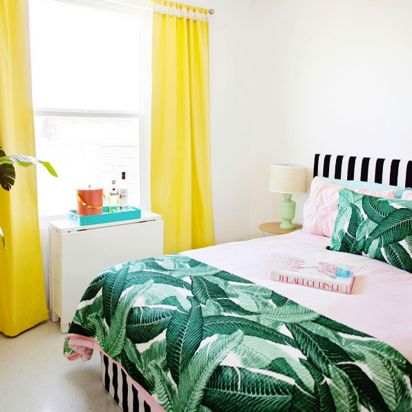 domino magazine bed with stripe headboard and banana leaf bedding