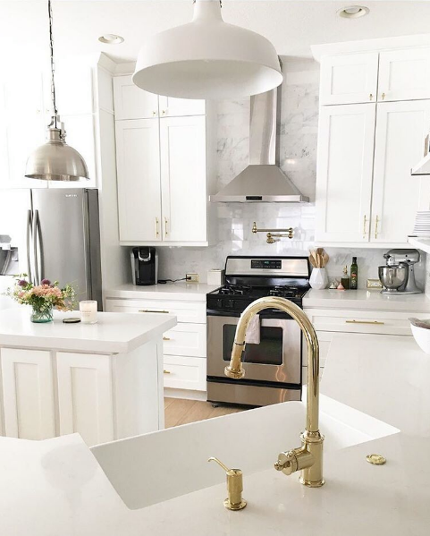 domino magazine white kitchen with brass faucets