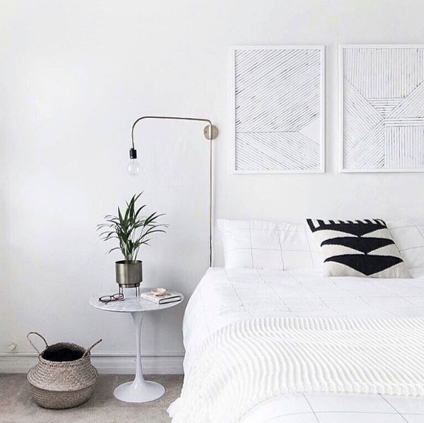 domino magazine all white bedroom with hanging art as headboard