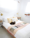 domino magazine white bedroom with blush pink quilt
