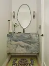 Small bathroom with blue stone floating vanity and tiger rug. 