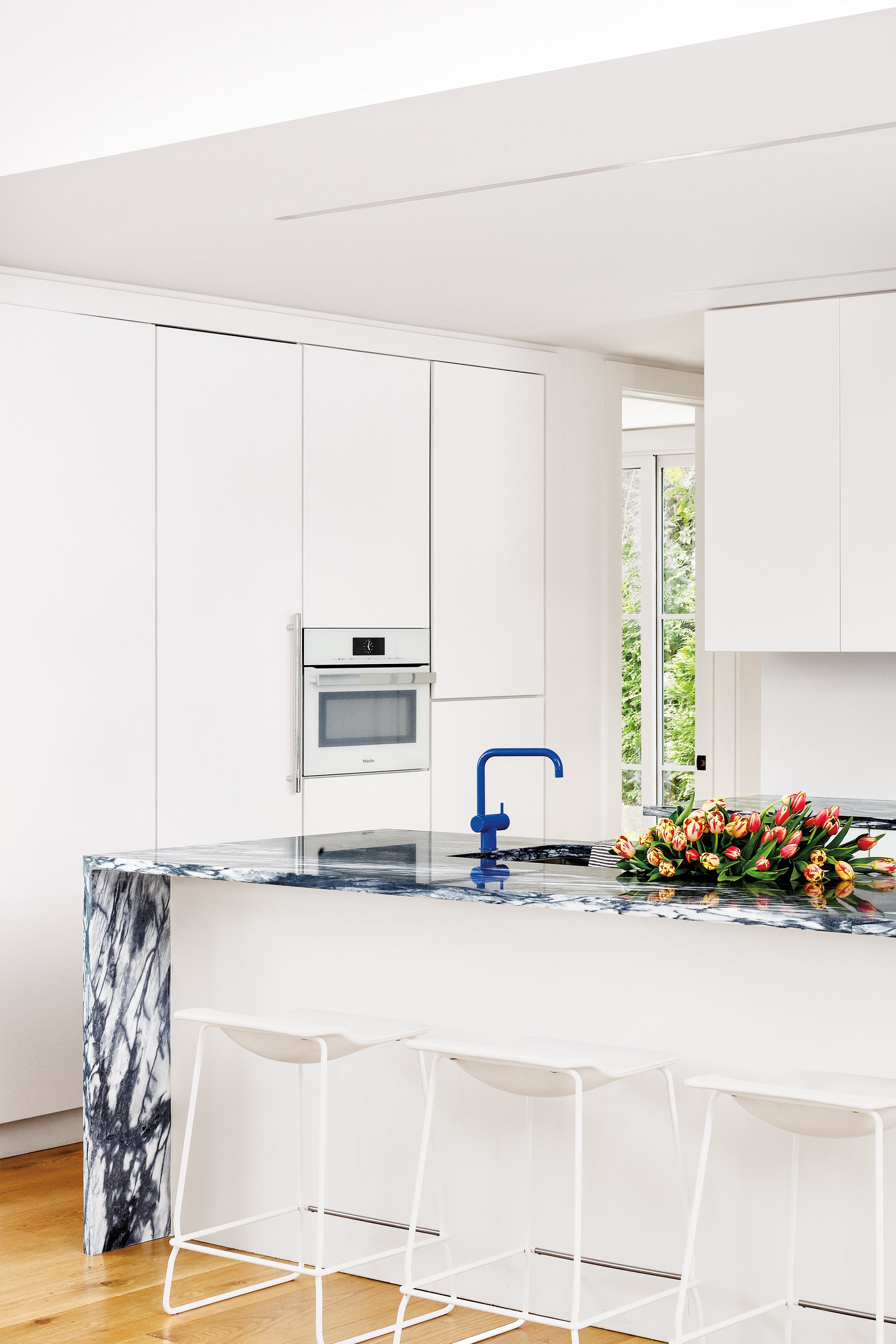 white kitchen with blue stone island