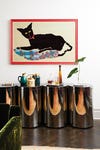 curvy metal console table with cat artwork above
