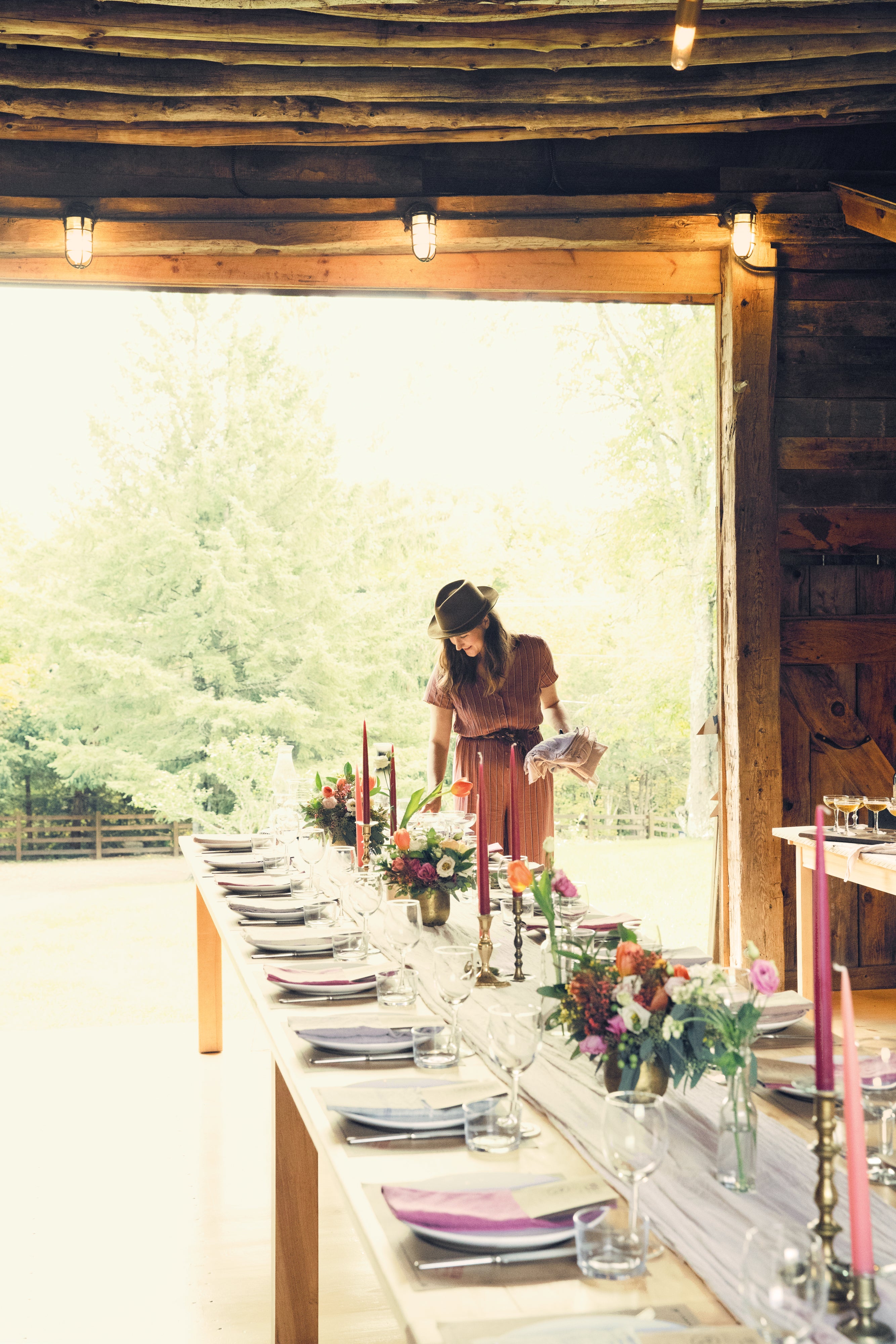 woman setting long table in barn