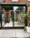 conservatory with black framed floor to ceiling windows and terrazo-like painted tile