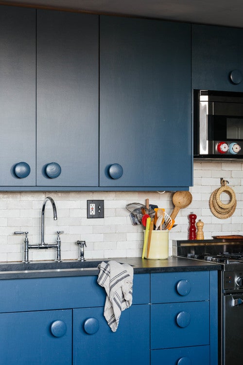 blue kitchen cabinets with round knobs