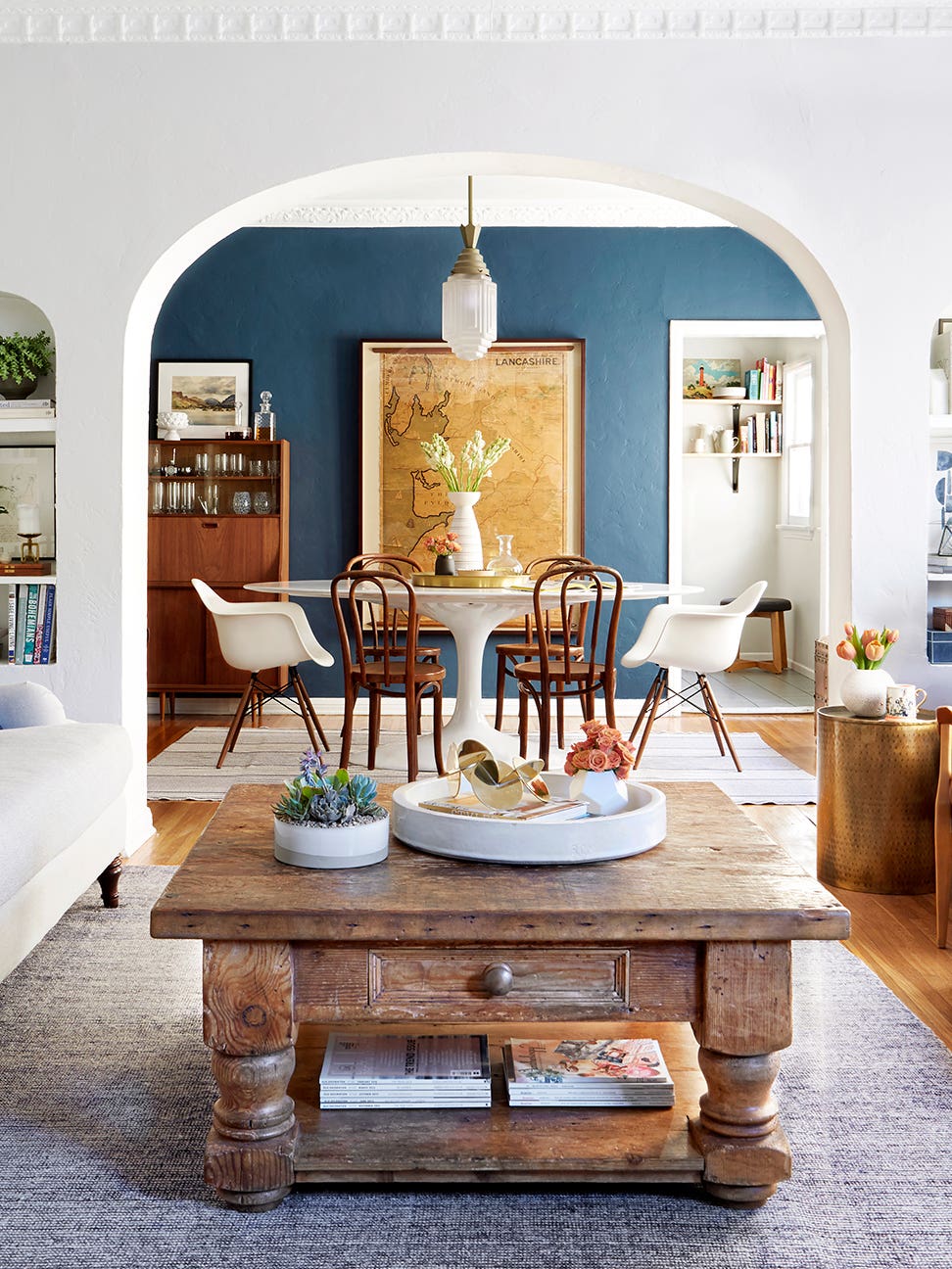 Dining room with rustic furniture and blue painted accent wall.