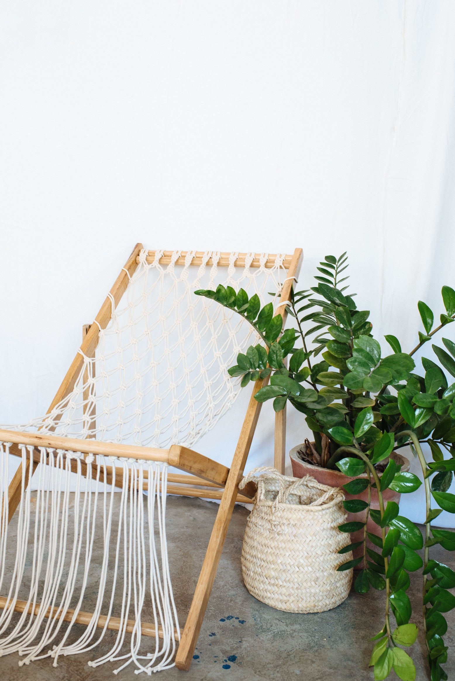 macrame chair next to a plant