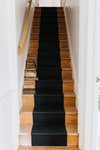 narrow wood stairs with black stripe down the center