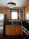 before image of a kitchen with brown cabinets and black counters