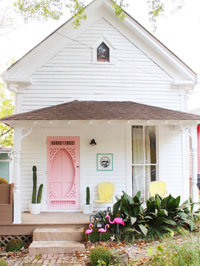 white cottage with a hot pink door