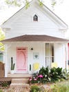white cottage with a hot pink door