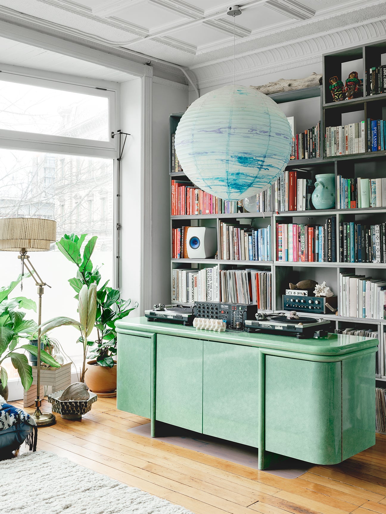 Room with green console and colorful bookshelf.