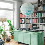 Room with green console and colorful bookshelf.