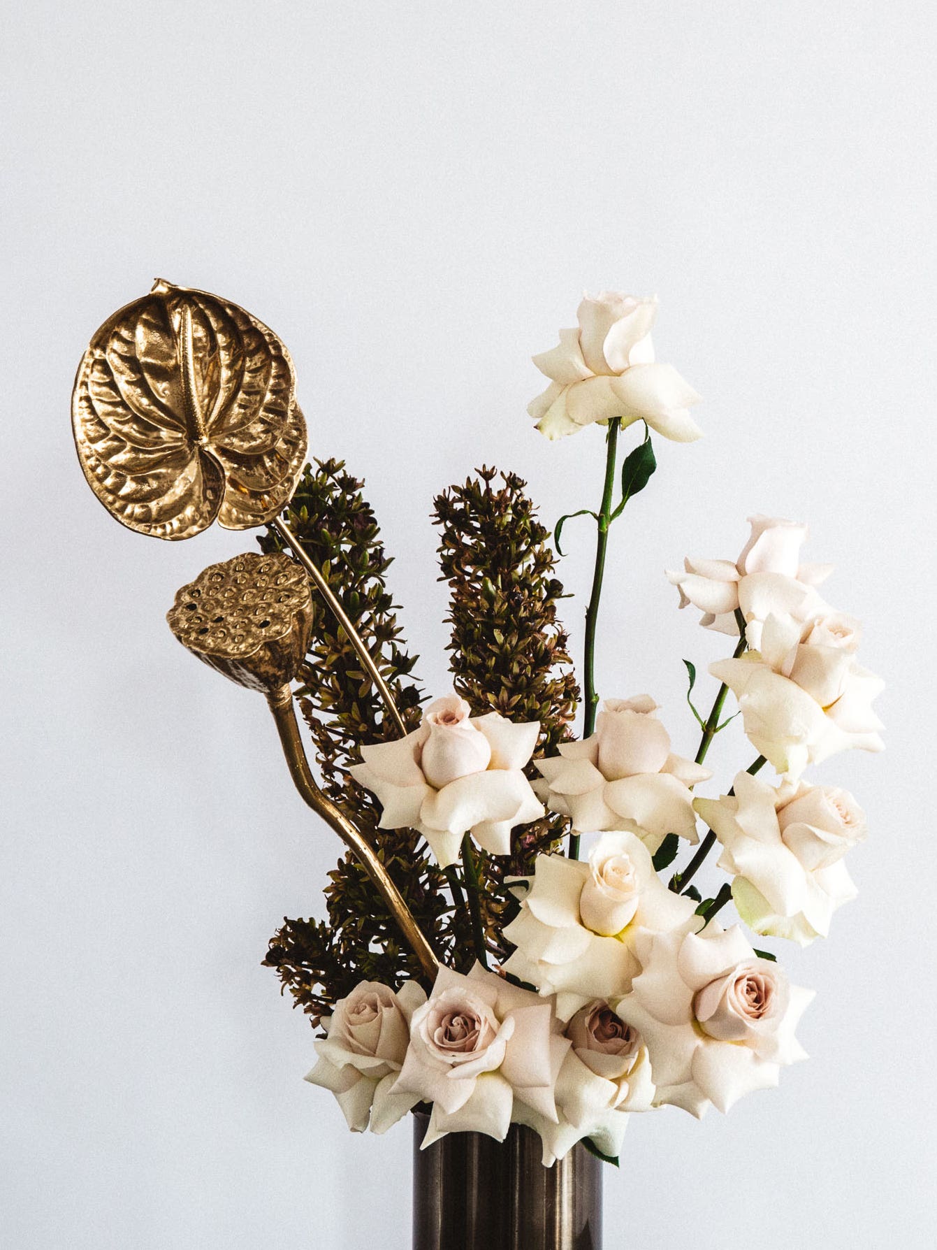 white floral arrangment with gold painted ranunculus
