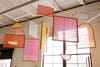 different wood frames with colorful yarn hanging from a living room ceiling