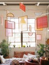 different wood frames with colorful yarn hanging from a living room ceiling