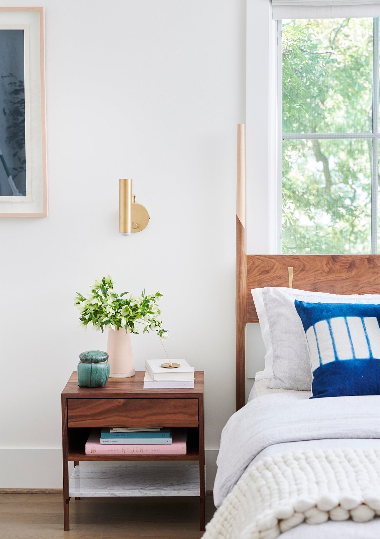 two toned wood bed frame next to a walnut nightstand 