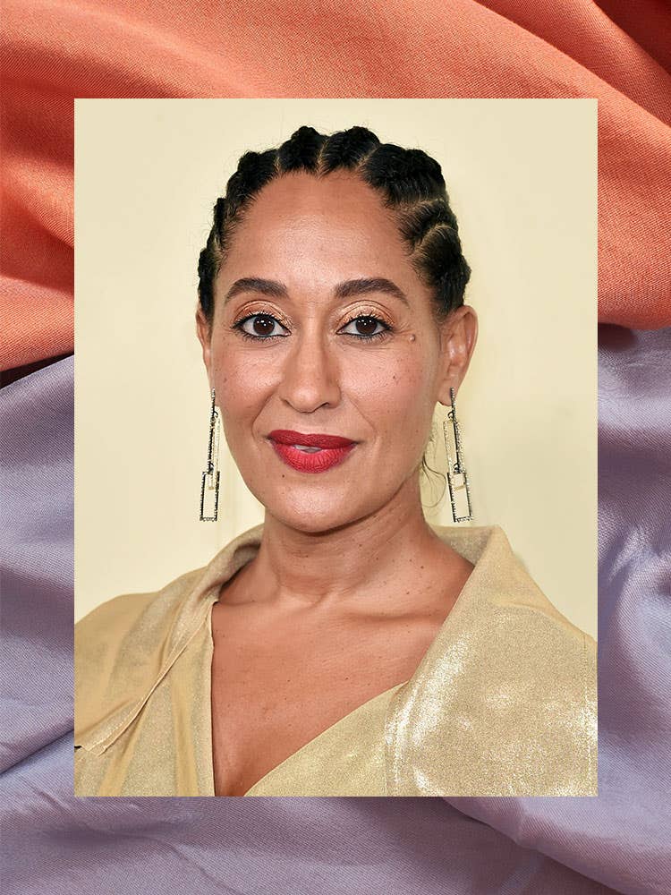 portrait of tracee ellis ross in a gold shirt with purple and red fabric border