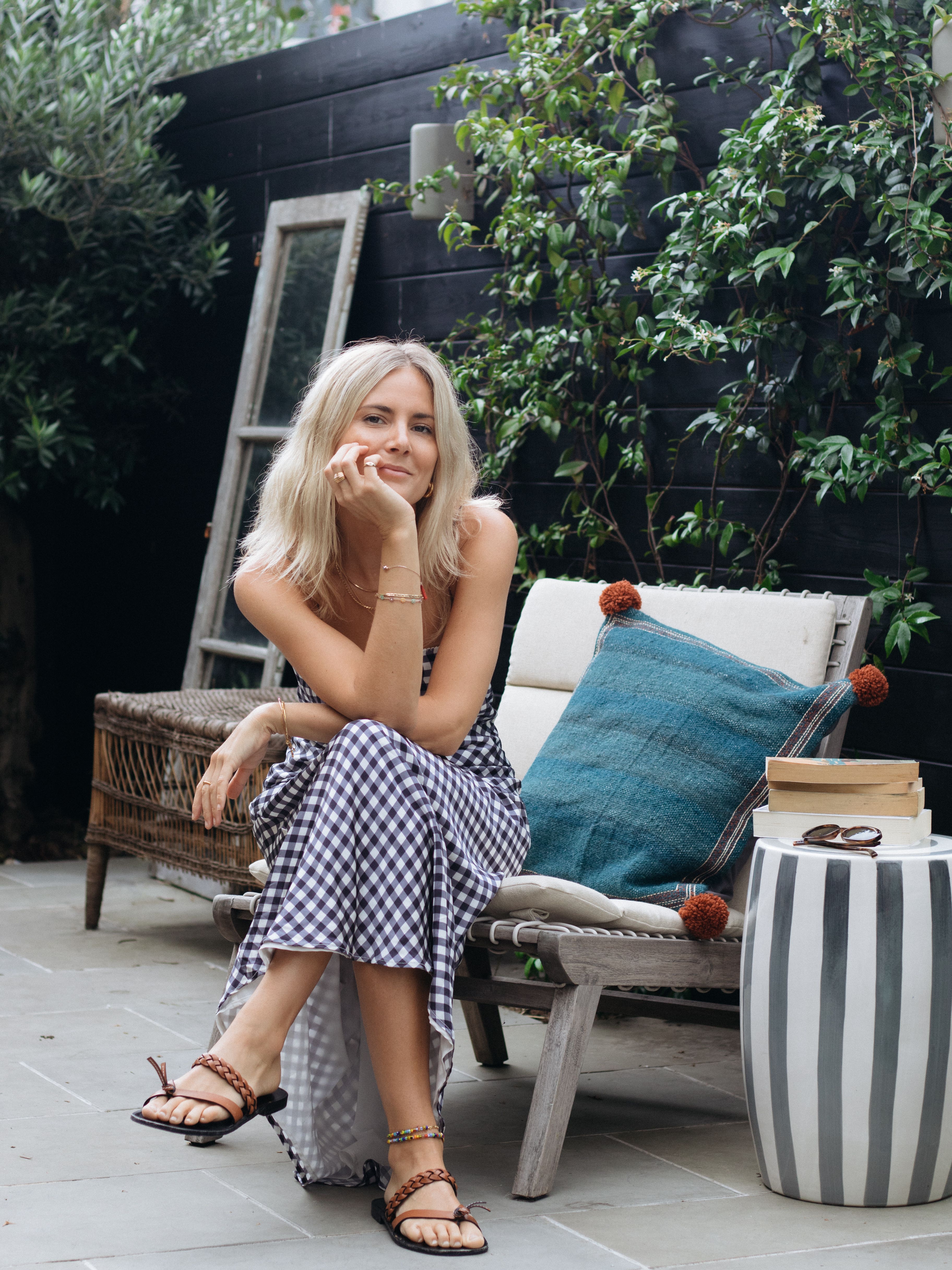 lucy williams sitting on a chair in her london backyard