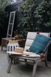 tufted outdoor chair with a denim pillow
