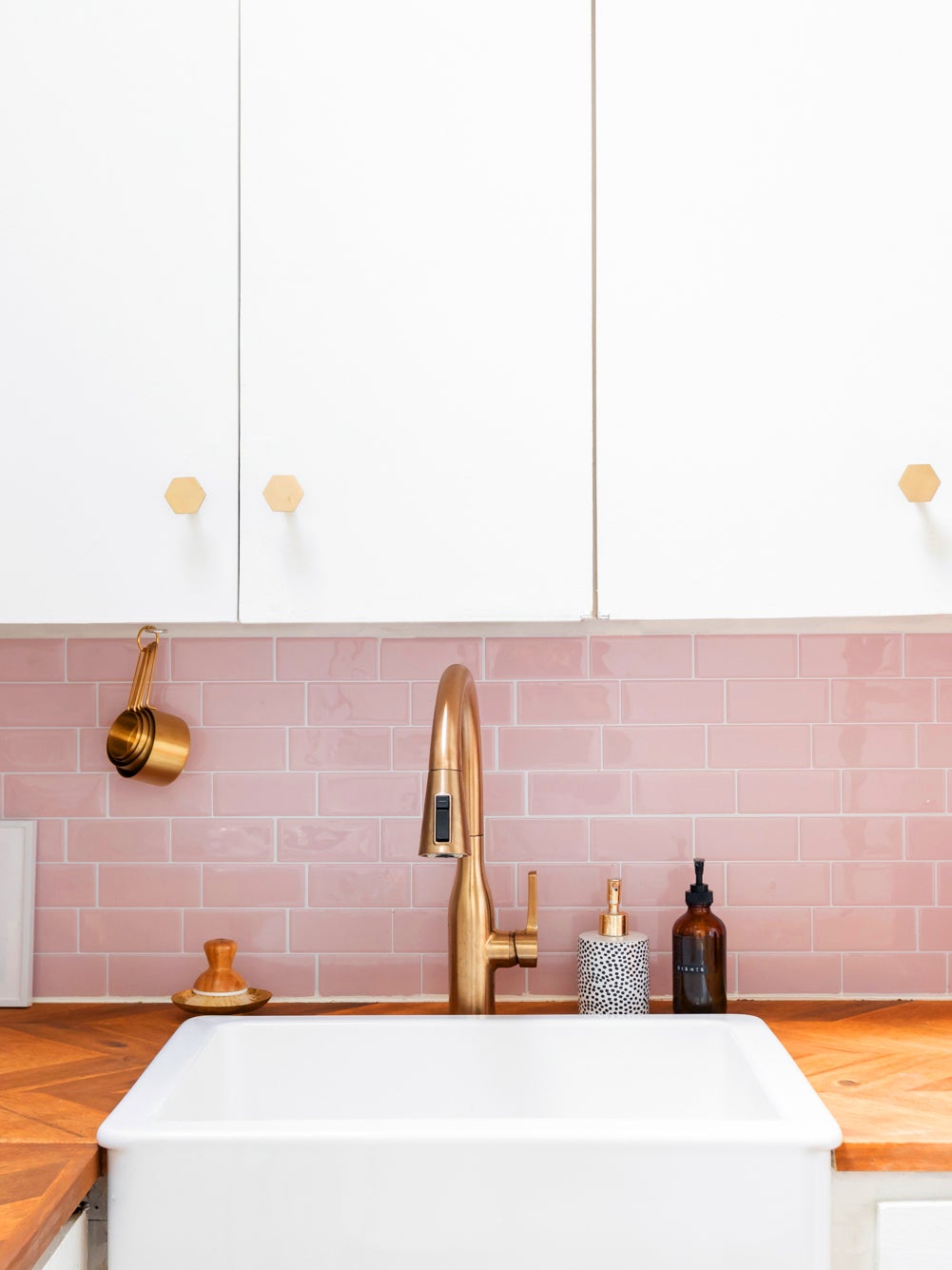 white kitchen cabinets with shiny pihnk subway tile backsplash