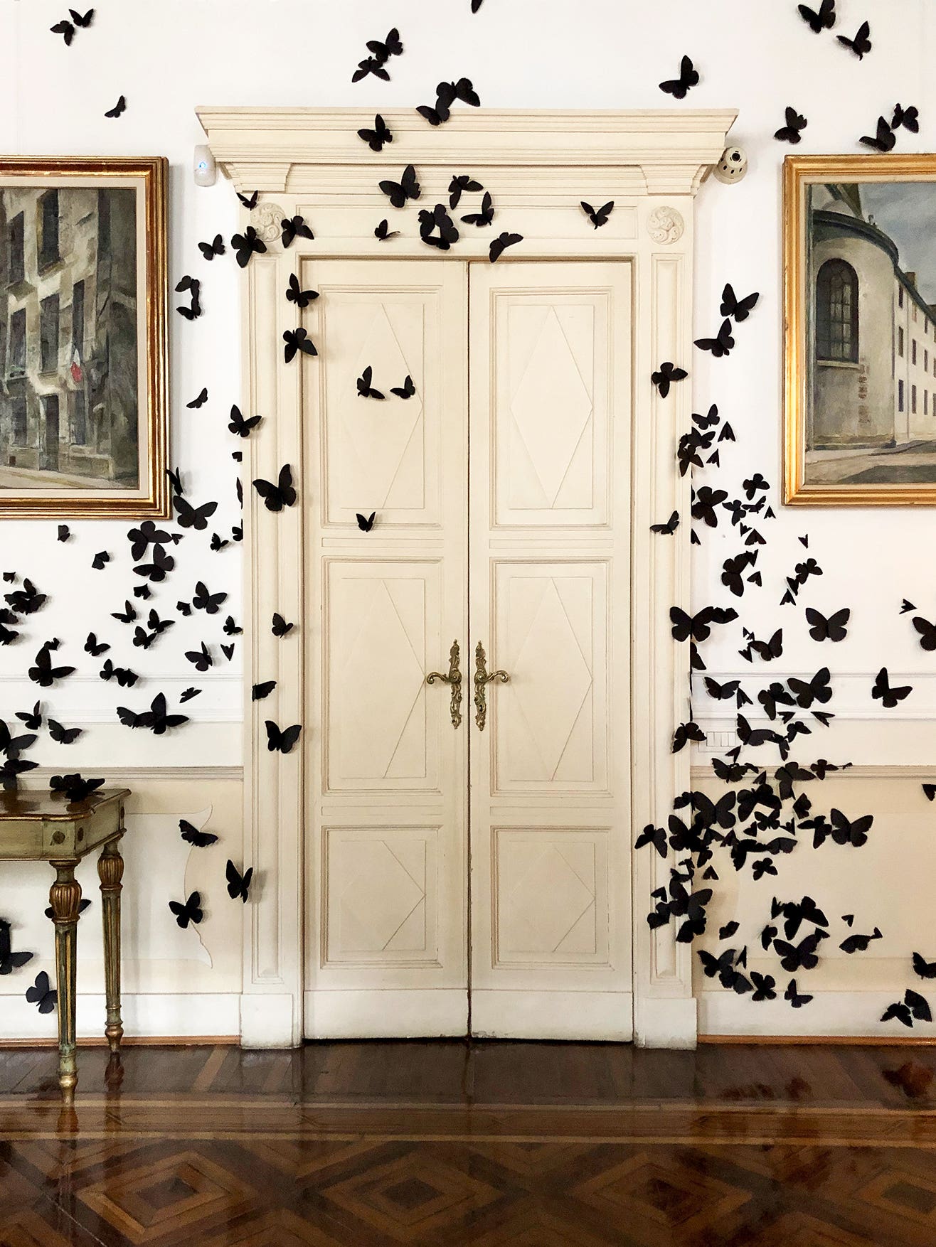 black butterflies swarm around an old doorway
