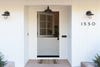 tan colored dutch door with a plain welcome mat and white exterior house