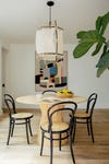 dining room with light wood table, black and cane dining chairs