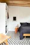 guest bedroom with black and white tile and terra cotta side tables
