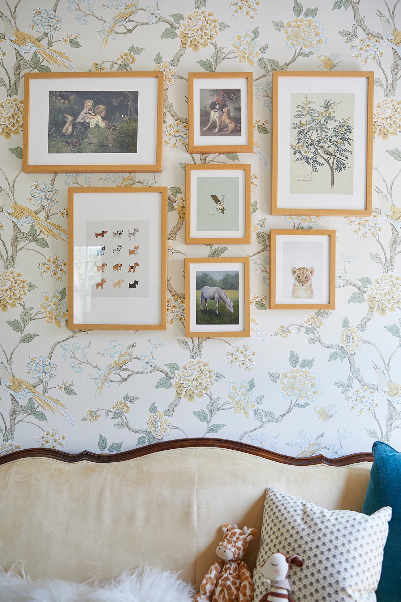 antique yellow sofa with gallery wall and floral wallpaper
