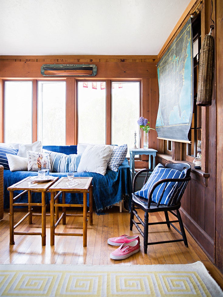blue sofa with blankets in a wood paneled room